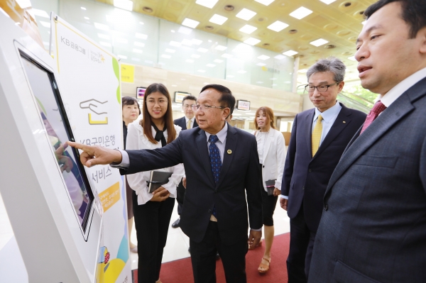 4일 KB국민은행 여의도영업부를 방문한 (가운데)우한조(U Han Zaw) 미얀마 건설부장관이 지능형창구안내시스템(IQS)를 직접 체험해 보고 있다. [사진=KB국민은행]