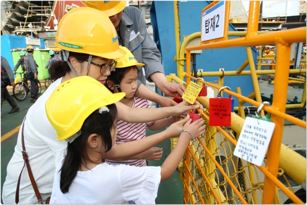 대우조선해양 임직원 가족들이 안전메세지를 담은 안전열쇠를 채우고 있다. [사진=대우조선해양]